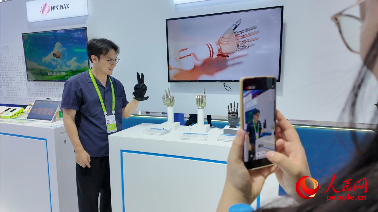 第五届消博会现场，观展人员体验智能仿生手。人民网 欧阳易佳摄