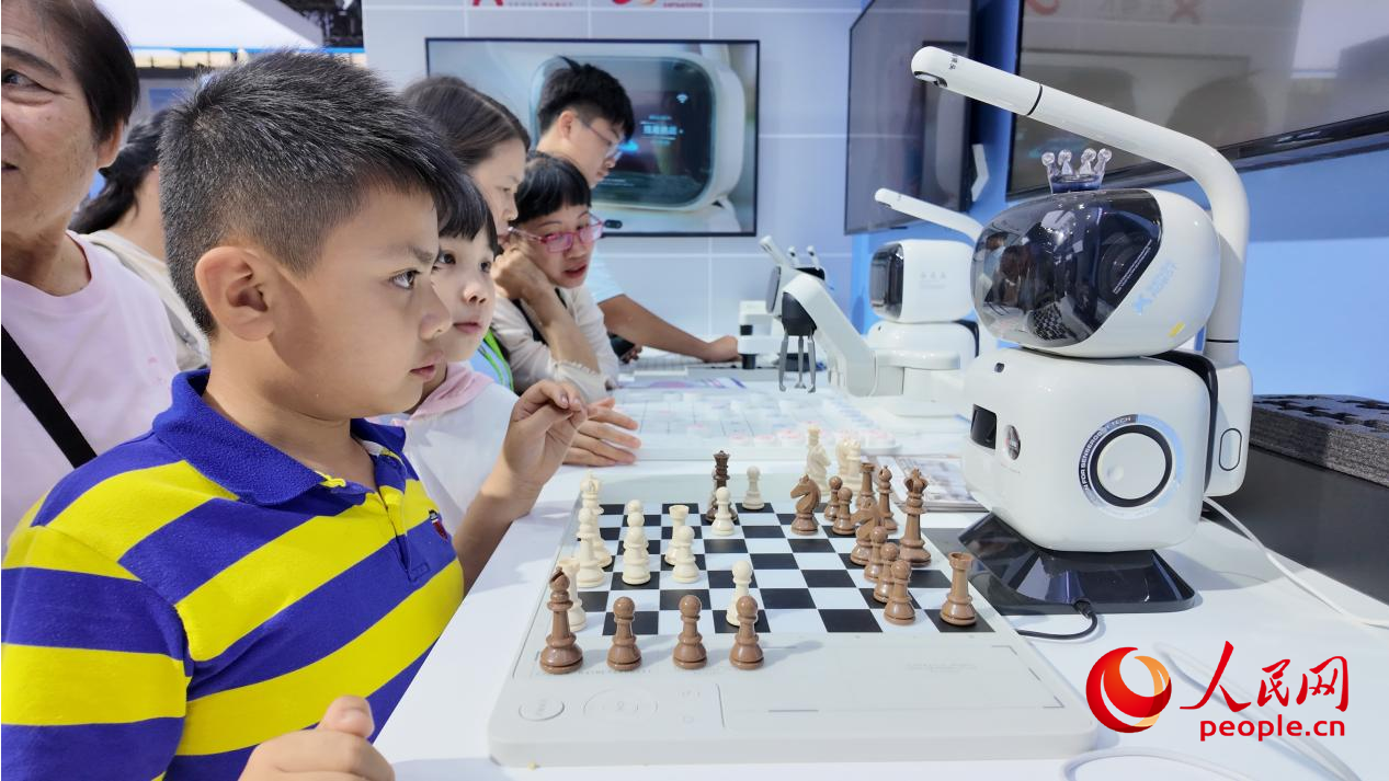 参观者与AI下棋机器人比拼国际象棋。人民网 欧阳易佳摄