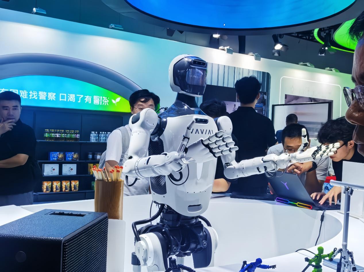 人形机器人与参展观众互动演示。顾若菲摄