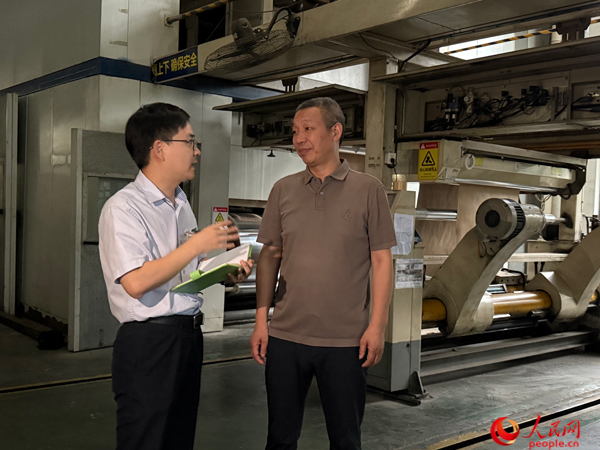 银行工作人员走访启越纸品。人民网记者 杜燕飞摄