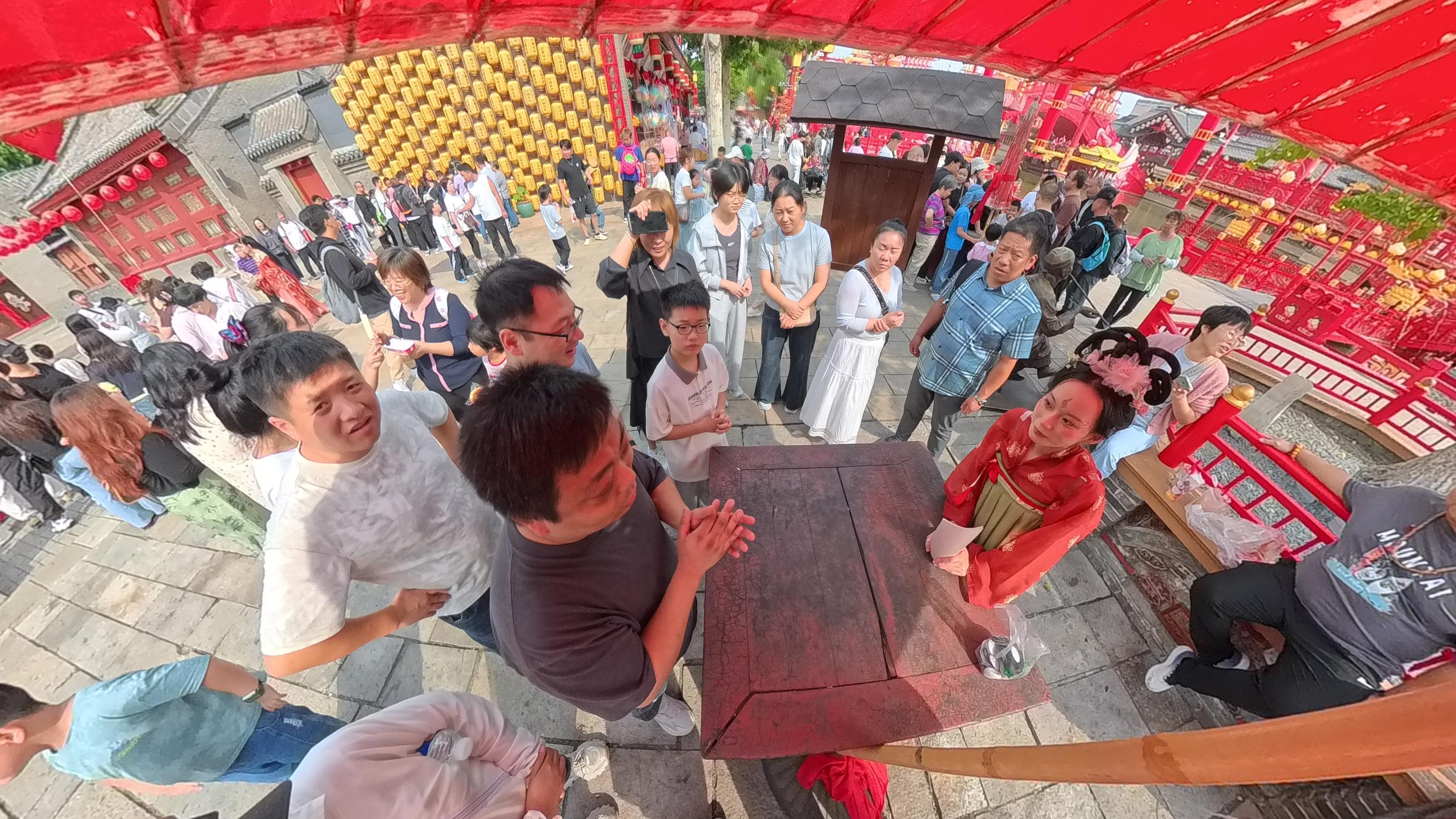 景区演员正在与游客进行“谜字”游戏。人民网记者 王天乐摄