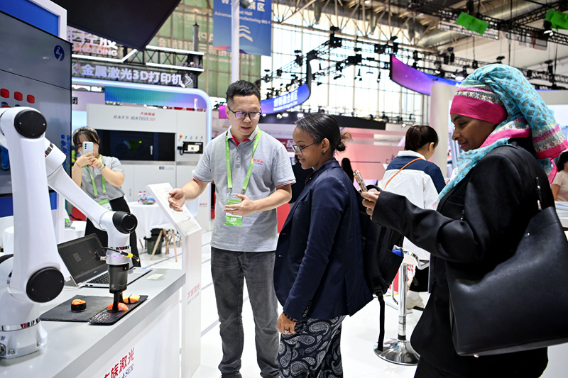 在第三届中国国际供应链促进博览会先进制造链展区,来自国外的观众正在参观协作机器人。人民网记者 翁奇羽摄