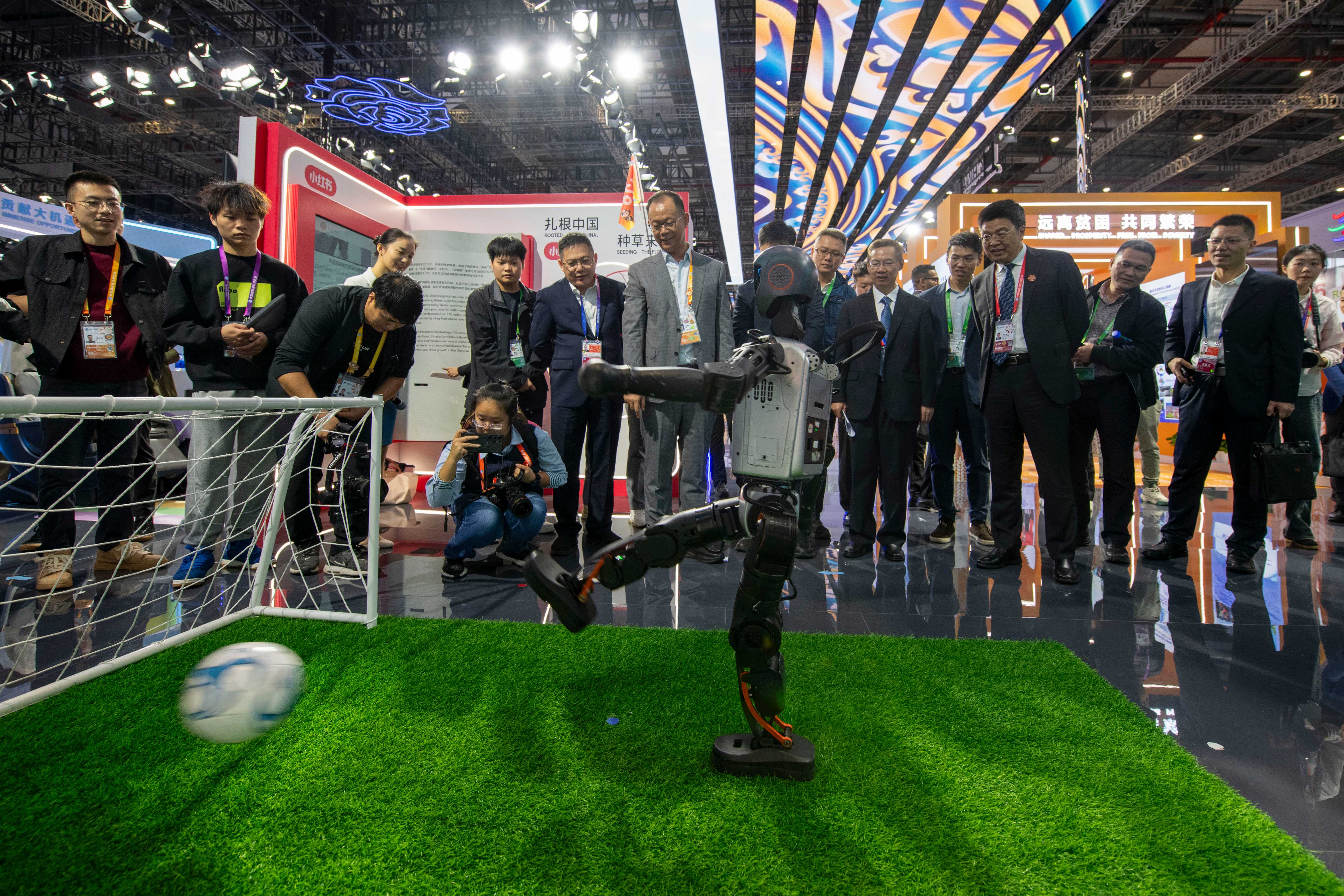 在第八届进博会中国馆,人形机器人踢球射门,吸引不少参观者驻足。人民网记者 翁奇羽摄