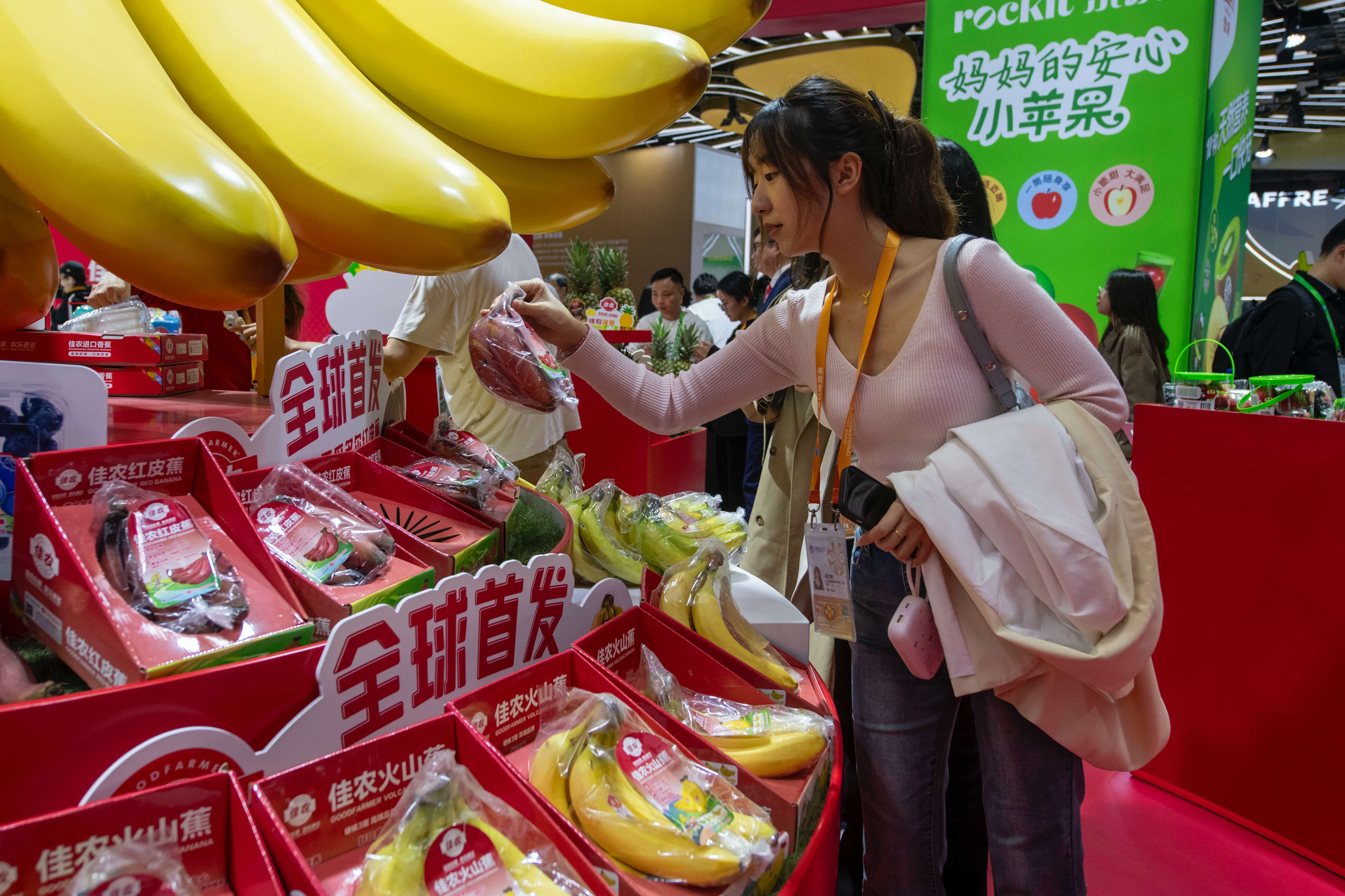 在第八届进博会农食产品展区的佳农展台，全球首发的厄瓜多尔红皮蕉吸引观众目光。人民网记者 翁奇羽摄