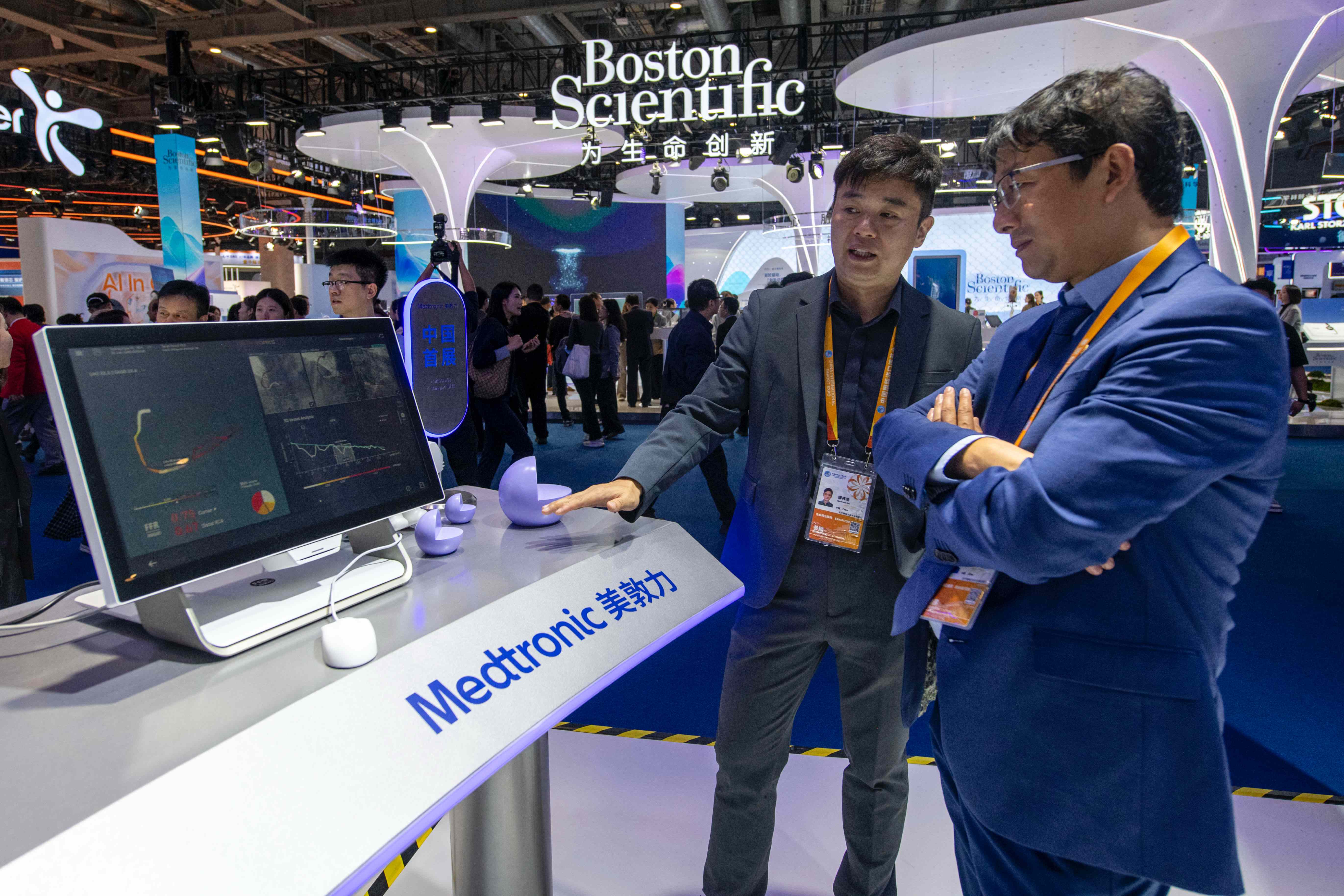 在第八届进博会医疗器械及医药保健展区的展台，工作人员正在向参观者介绍中国首展的用于诊断心血管疾病的CathWorks FFRangio系统。人民网记者 翁奇羽摄