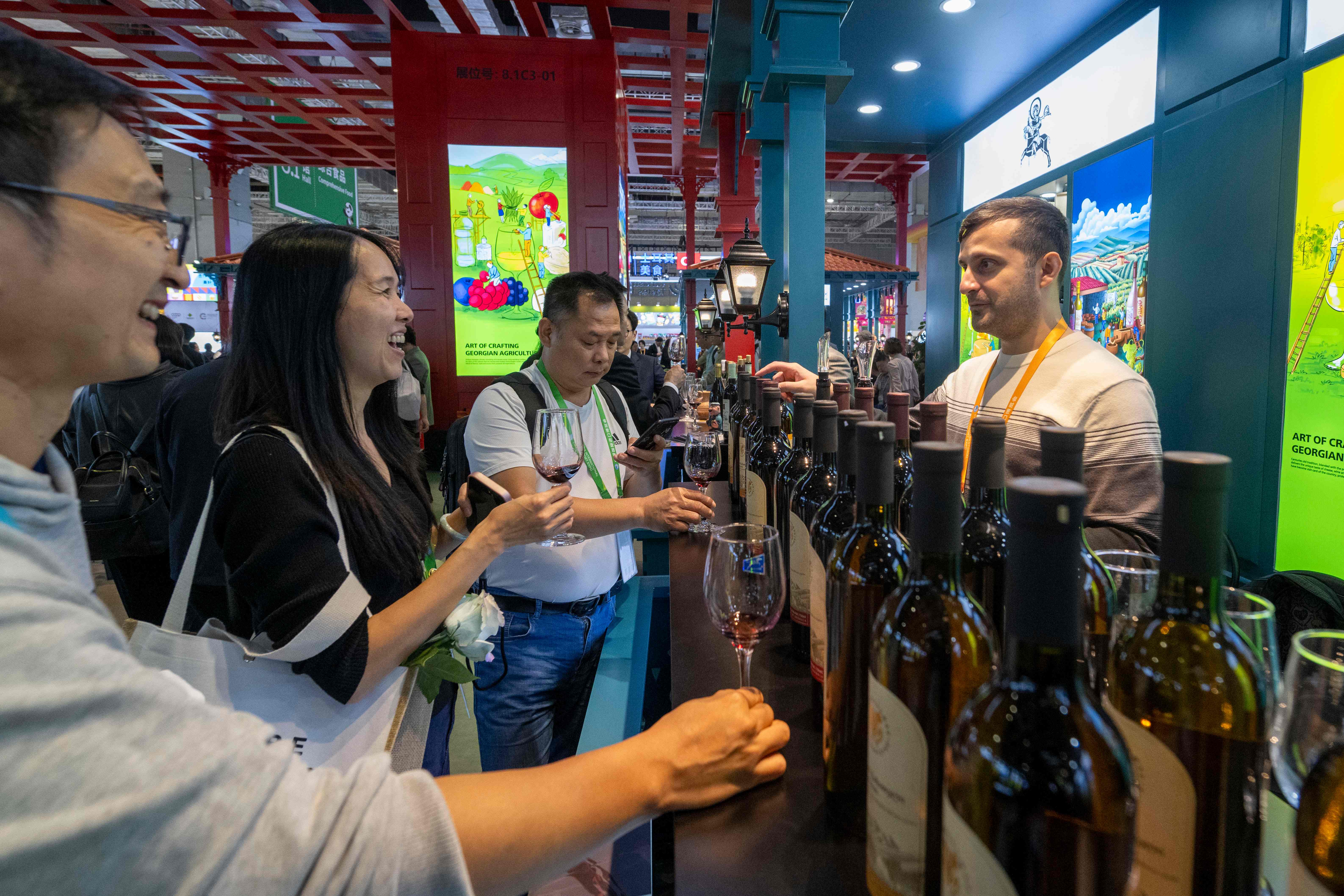 11月6日，在第八届进博会农食产品展区，参观者正在品尝来自格鲁吉亚的葡萄酒。人民网记者 翁奇羽摄