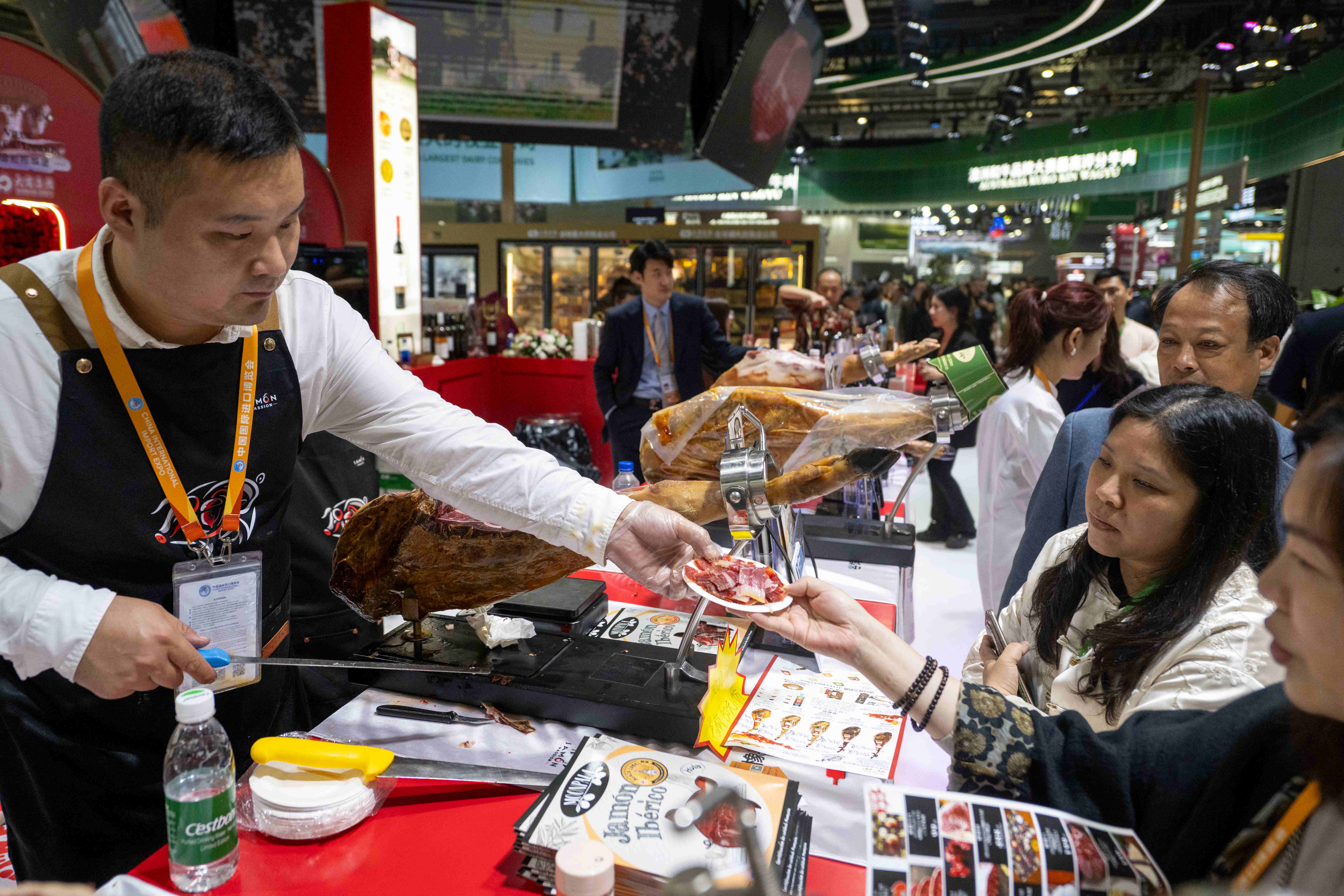 11月6日，在第八届进博会农食产品展区，来自西班牙的黑标火腿吸引众多参观者驻足品尝。人民网记者 翁奇羽摄