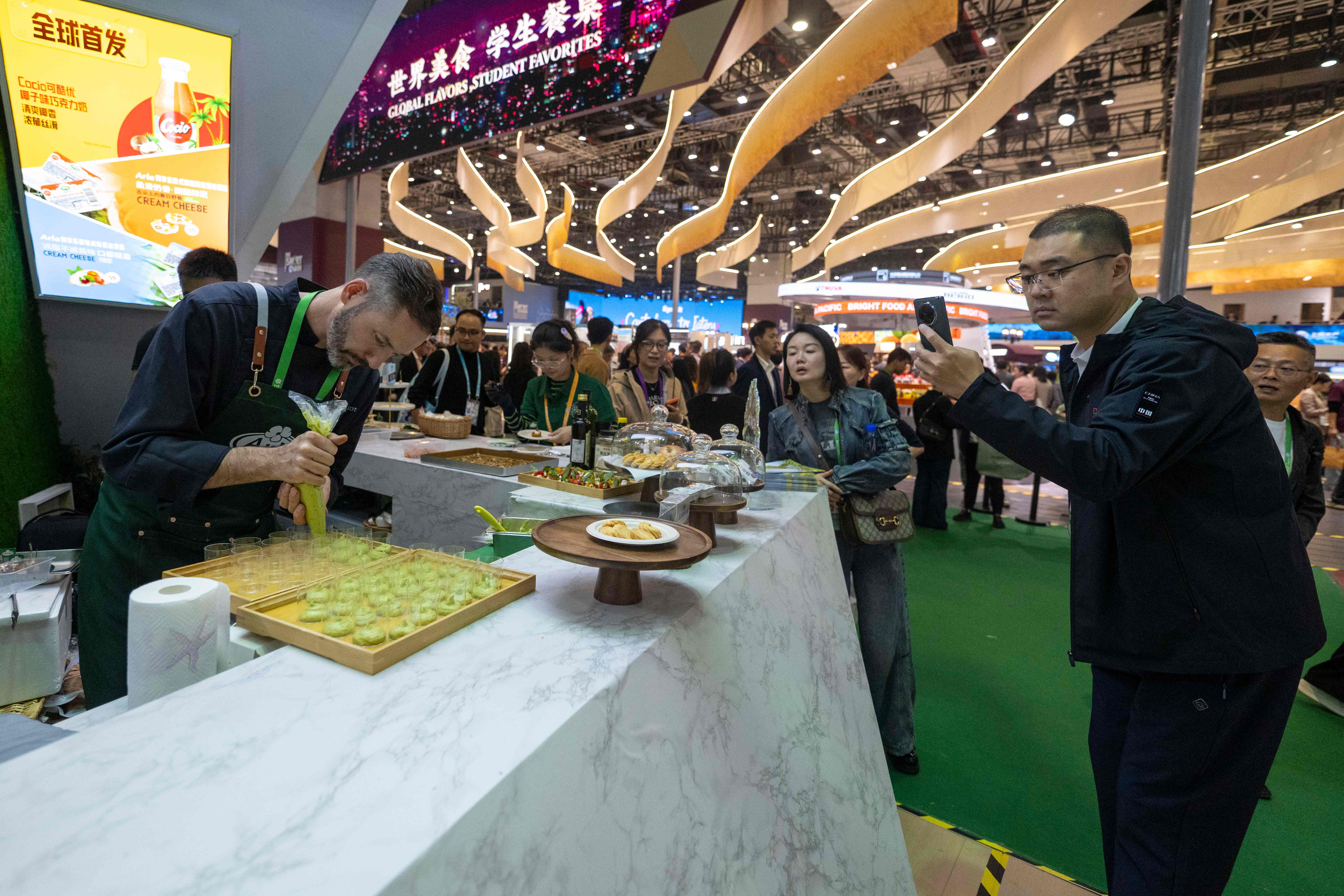 11月6日，在第八届进博会农食产品展区的Arla展台，米其林星厨现场秀厨艺。人民网记者 翁奇羽摄