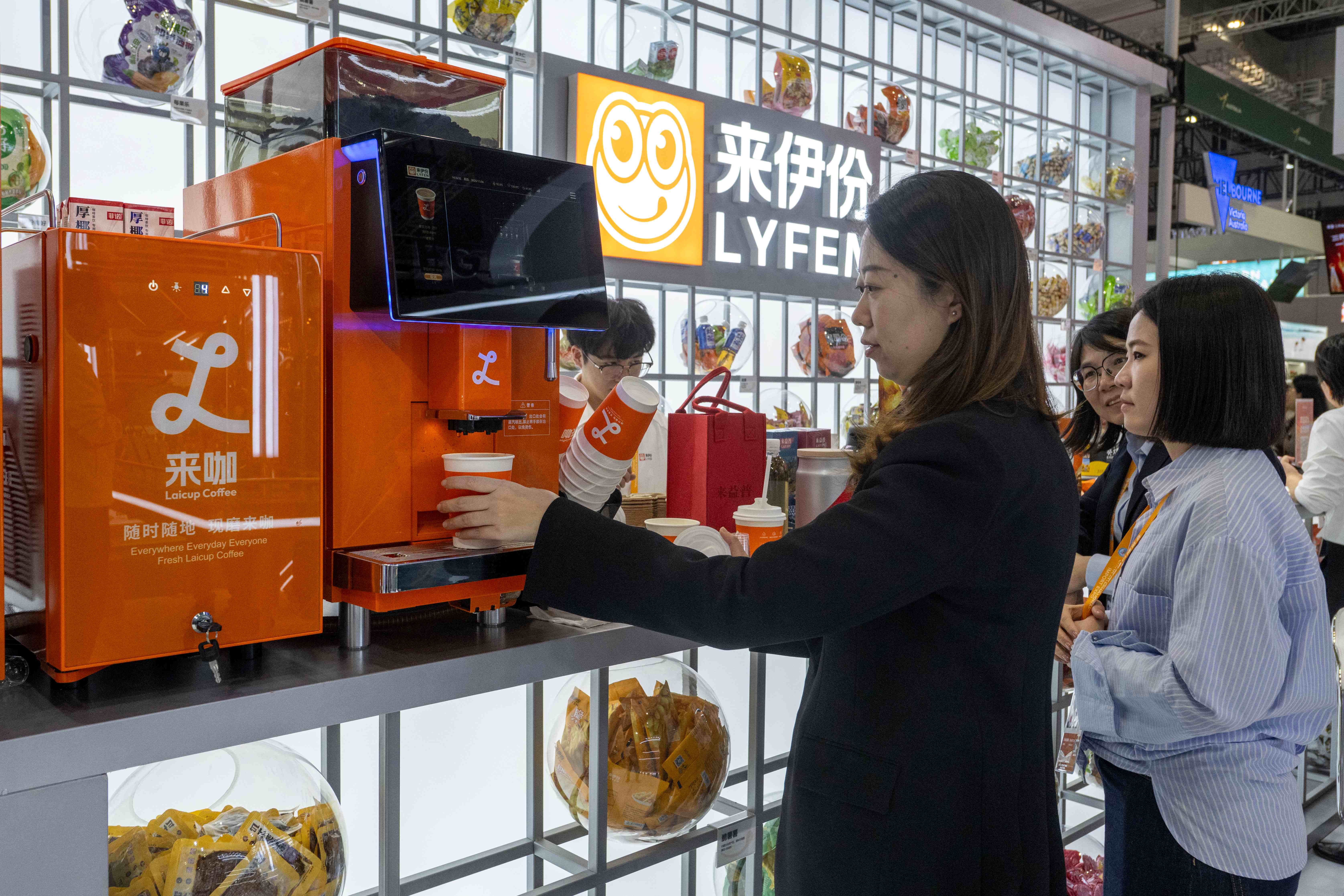 11月6日，在第八届进博会农食产品展区的来伊份展台，参观者驻足品尝特色咖啡。人民网记者 翁奇羽摄