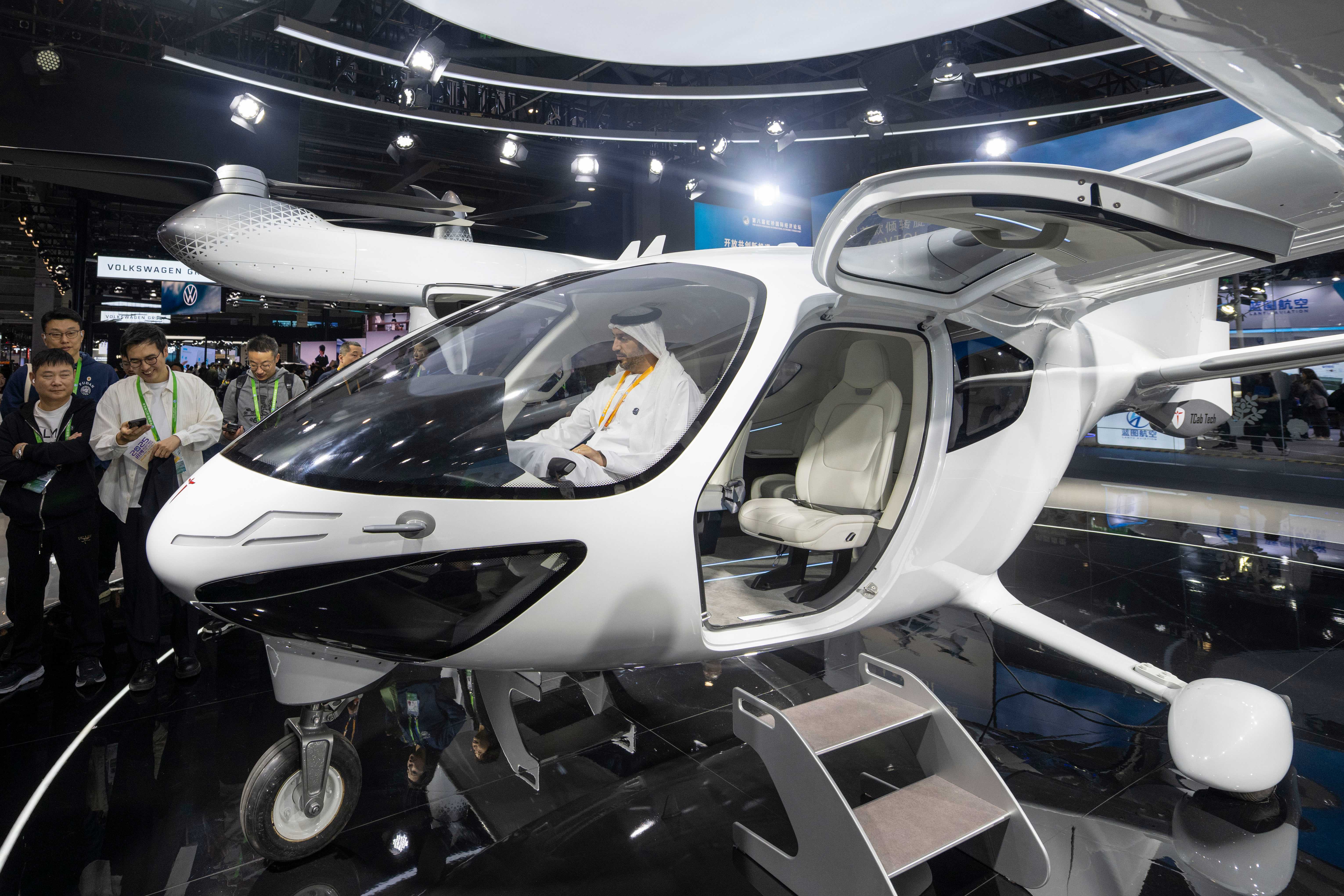 在第八届进博会汽车及智慧出行展区的时的科技展台，参观者体验倾转旋翼电动垂直起降飞行器。人民网记者 翁奇羽摄