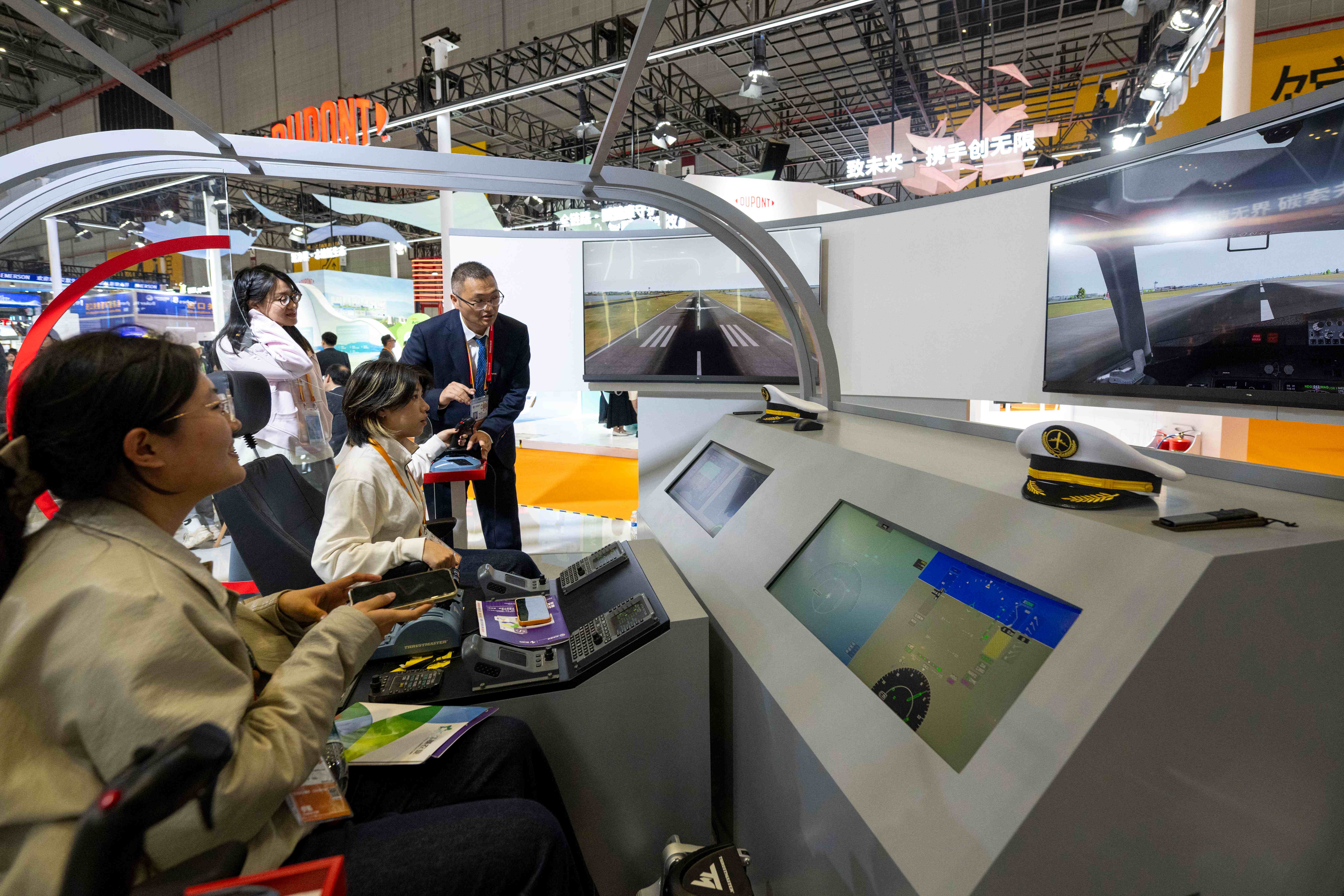 在第八届进博会技术装备展区的霍尼韦尔展台，参观者正在体验模拟飞行。人民网记者 翁奇羽摄