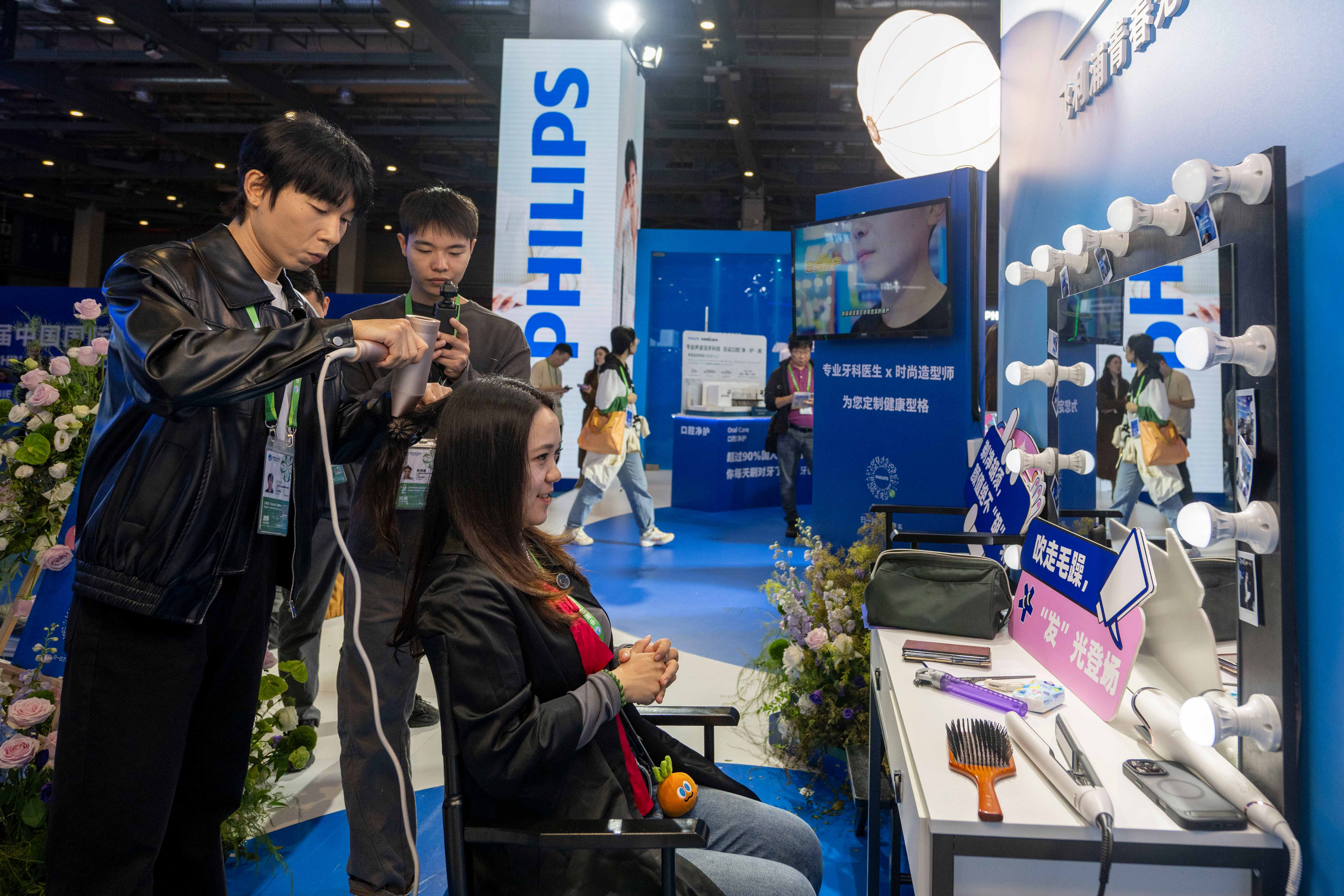 第八届进博会医疗器械及医药保健展区，参观者在飞利浦展台体验现场焕颜。人民网记者 翁奇羽摄