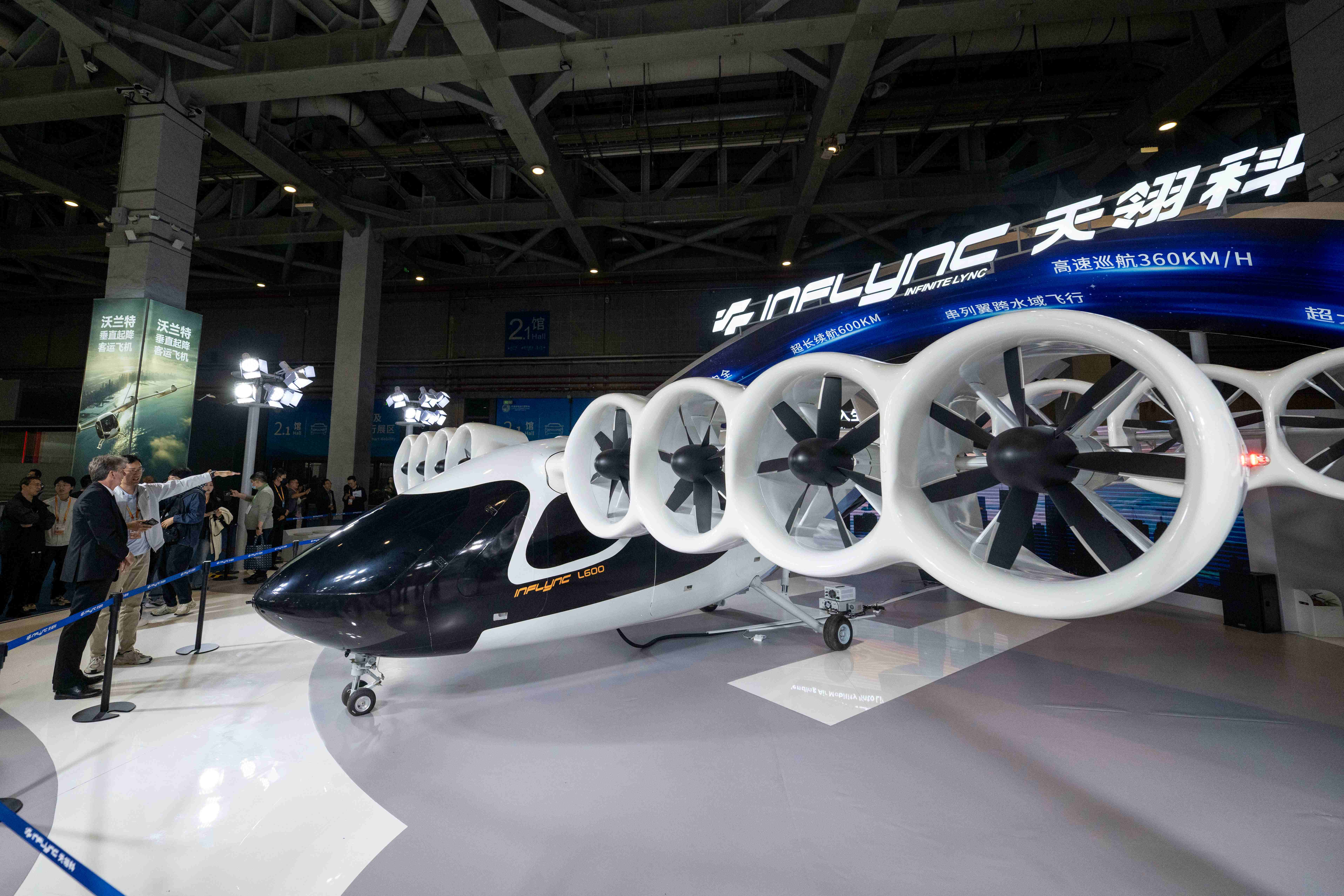 在第八届进博会汽车及智慧出行展区，观众正在参观天翎科L600空中专车。人民网记者 翁奇羽摄