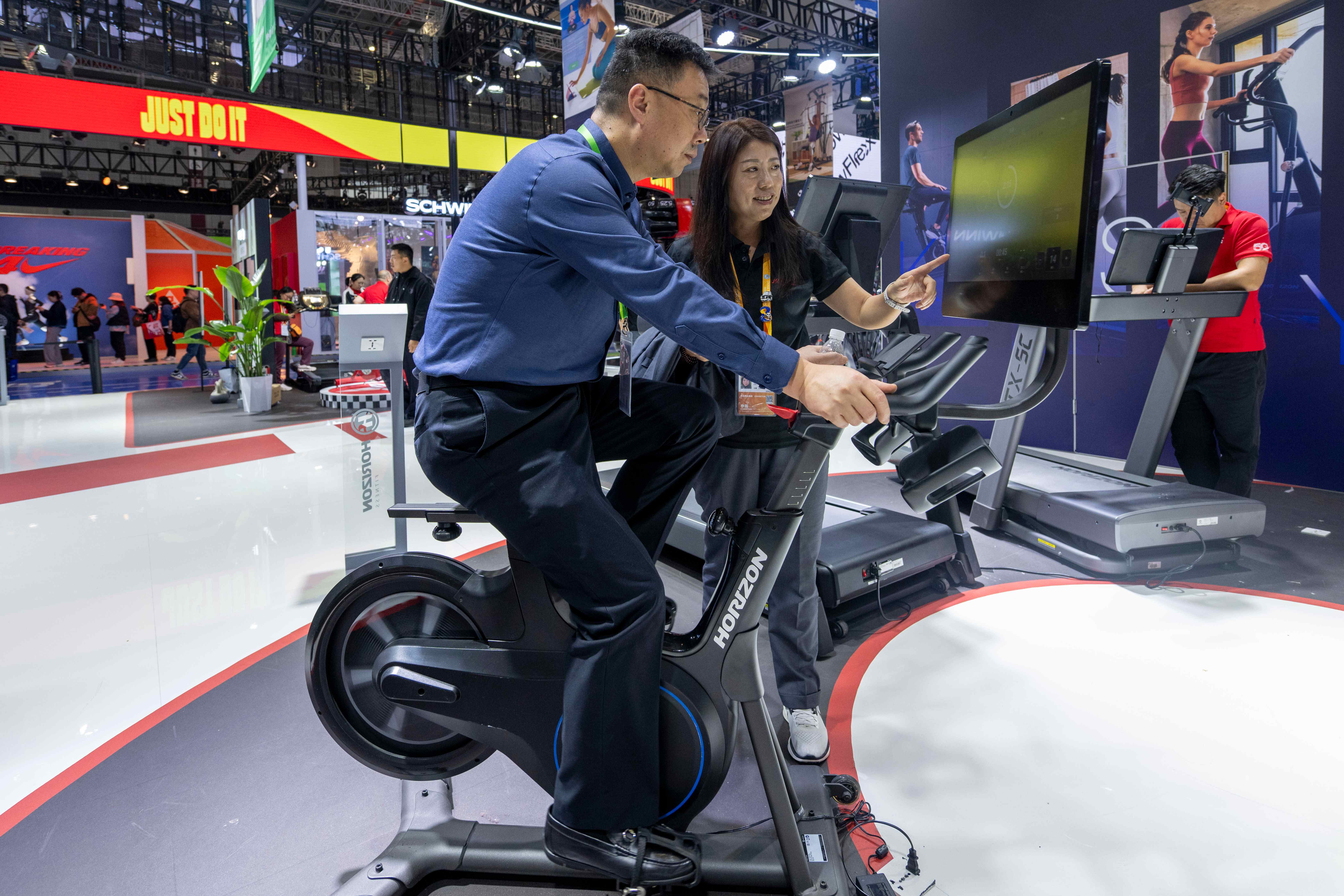 在第八届进博会消费品展区，参观者正在体验健身设备。人民网记者 翁奇羽摄