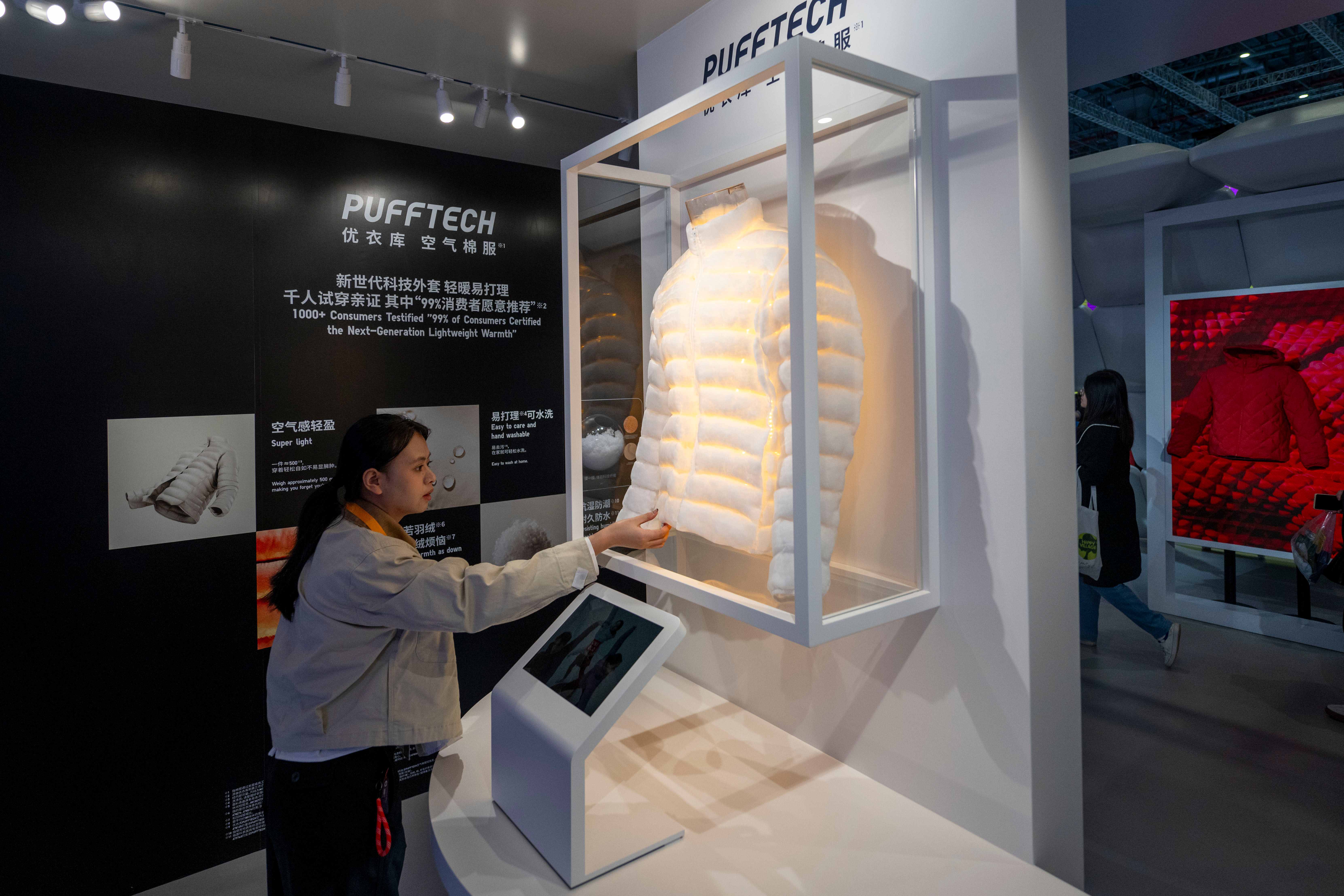 在第八届进博会消费品展区的优衣库展台，空气棉服吸引参观者目光。人民网记者 翁奇羽摄