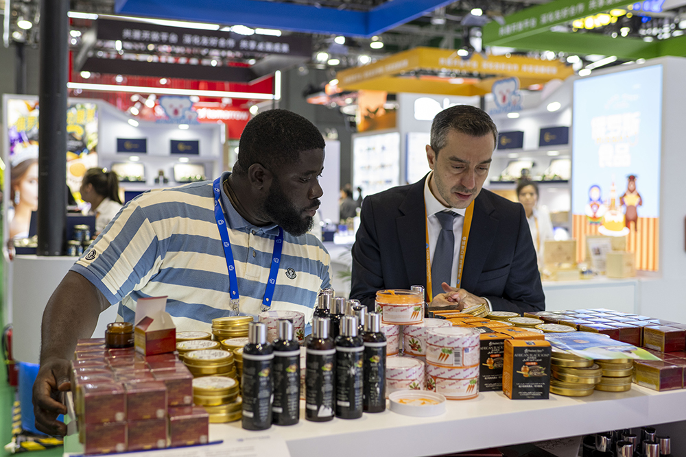 农食产品展区,外国参展商正在了解来自非洲的乳木果油护肤品。人民网记者 翁奇羽摄