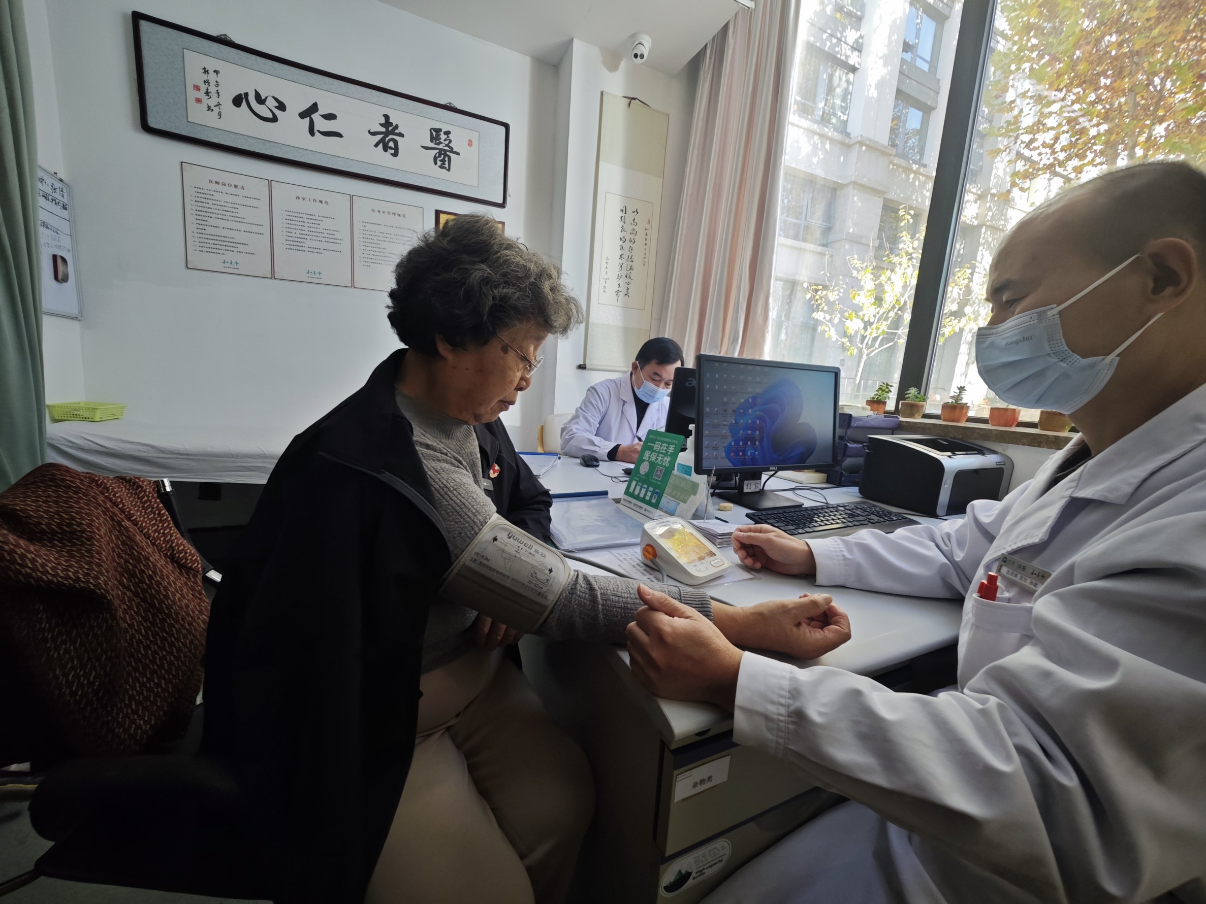 养老机构里的医务室里,老人正在测量血压。人民网记者 王天乐摄