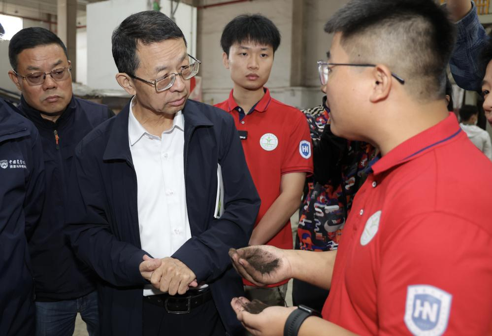 海南东方有机循环利用科技小院学生正在向张福锁及评审专家介绍其主导研发的有机肥。王晓摄