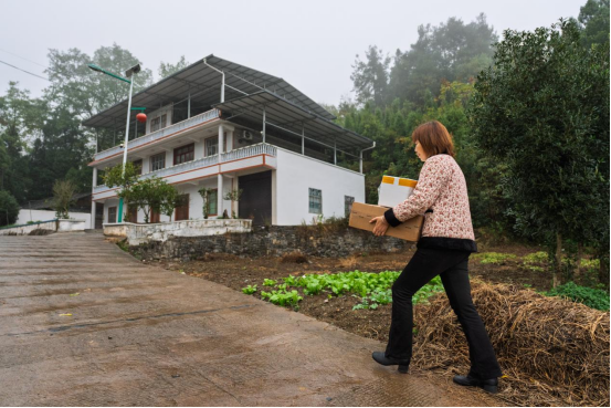▲刘美容为取货不便的村民提供快递送货上门服务。李雨恒摄