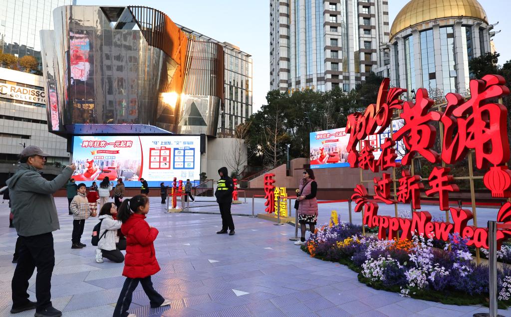 1月3日，市民游客在上海南京东路步行街世纪广场上的春节装饰前拍照。新华社记者 方喆 摄