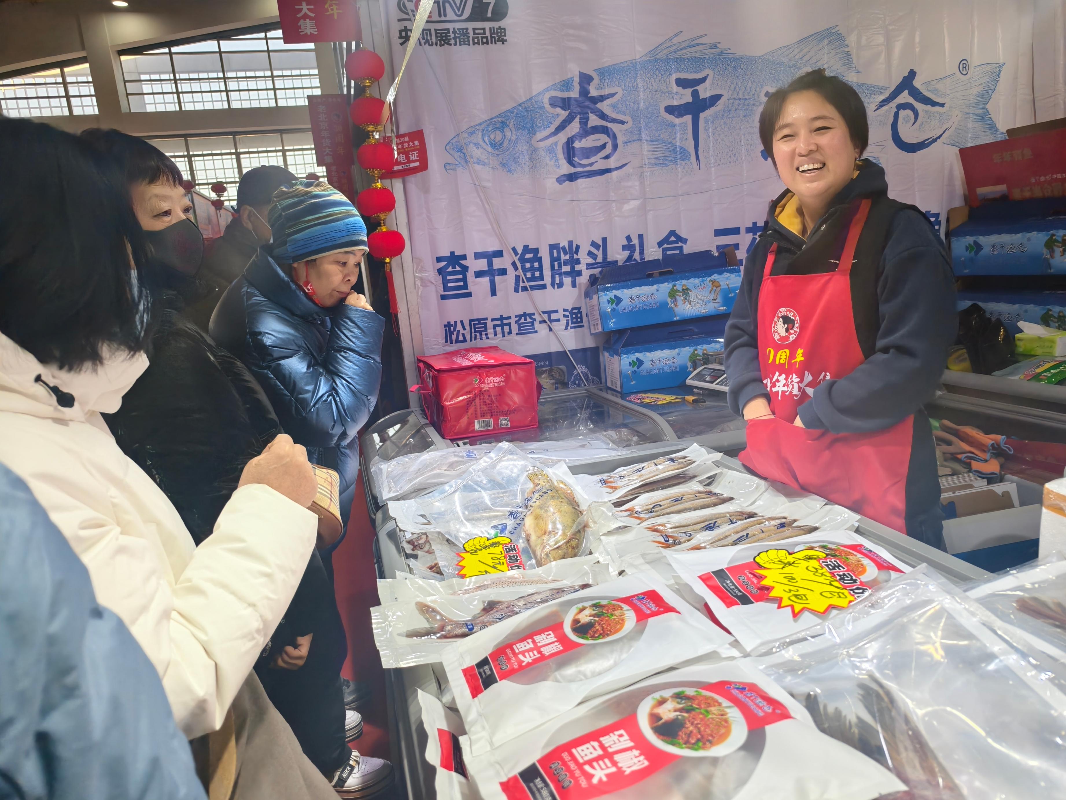 在北京鲜活农产品批发市场，商户与前来选购水产品的市民热情交谈。人民网记者 王天乐摄