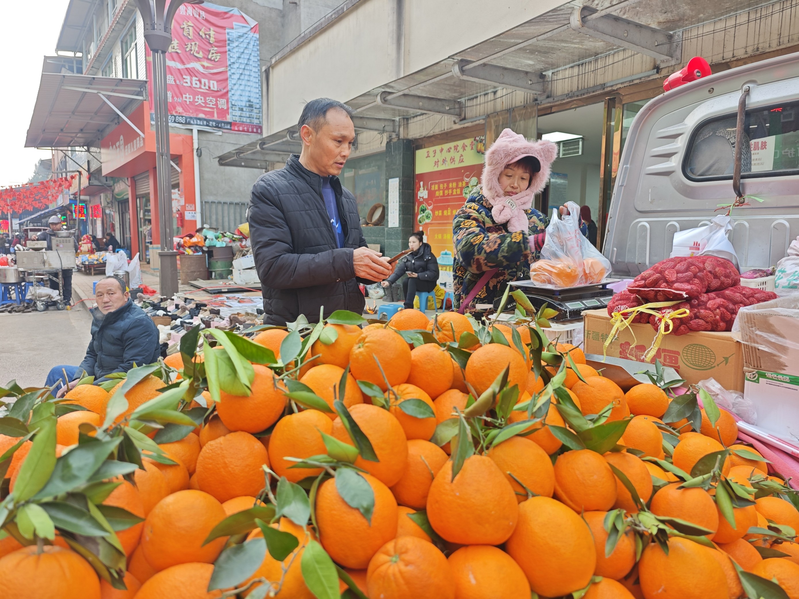 四川广元卫子镇大集上售卖橙子的摊位。人民网记者 王天乐摄