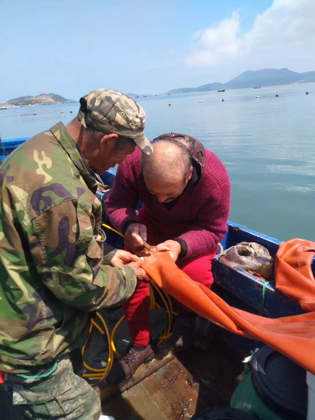 老张和水手们在修潜水服。祝铭旋摄