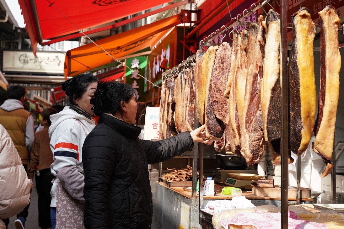 消费者在农贸市场挑选牛干巴。人民网记者 蔡树菁摄