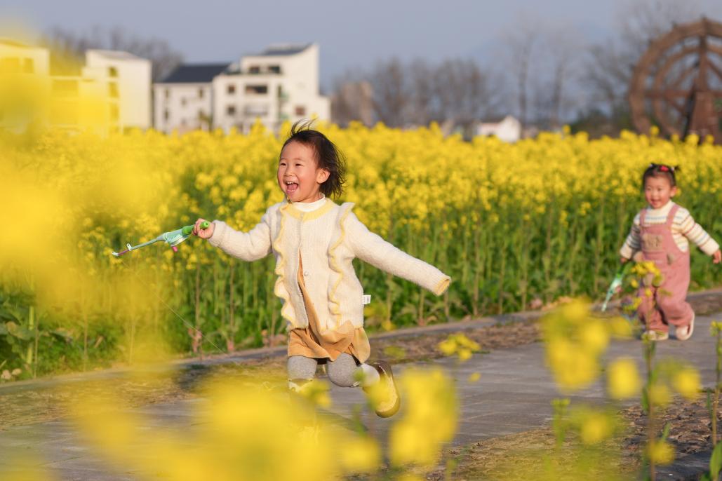 3月11日，小朋友在桐庐县梅蓉村油菜花田间奔跑、玩耍。 新华社记者 黄宗治 摄