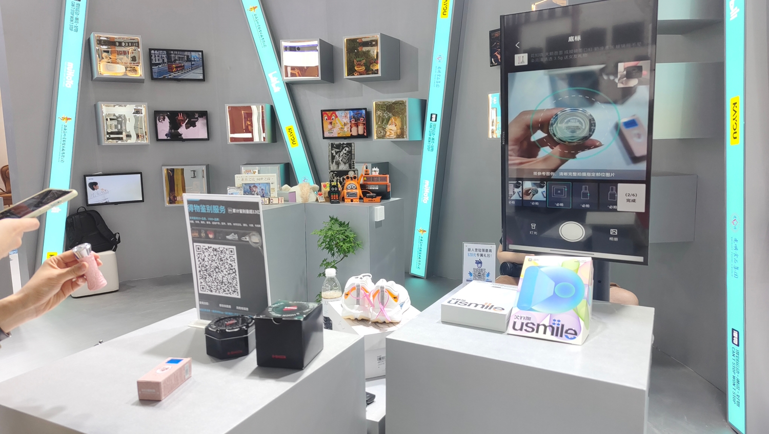 在上海展馆内，一些消费者被得物在线鉴别服务吸引，纷纷掏出手机体验科技创新带来的购物新便利。人民网记者 李彤摄