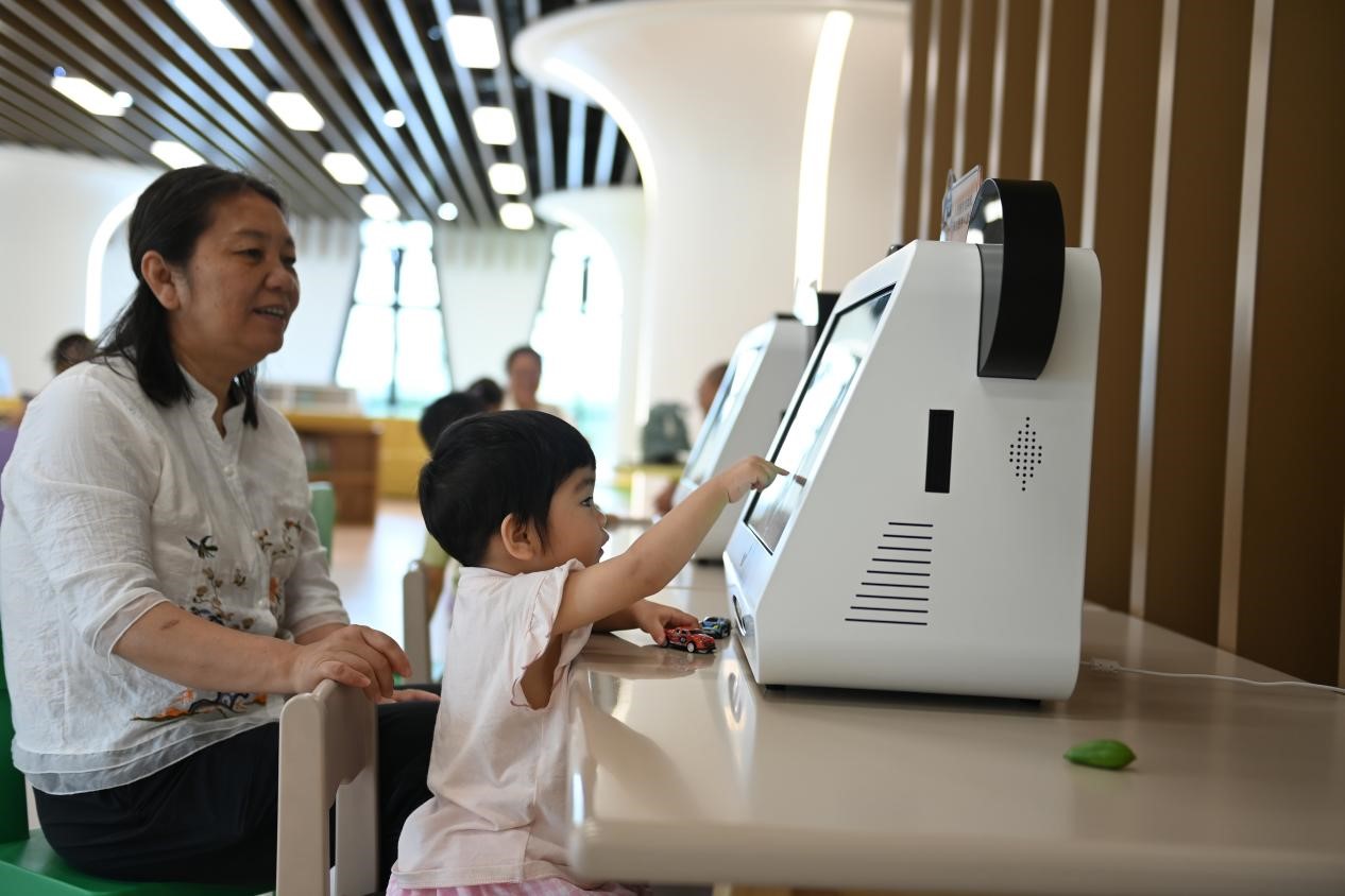 雄安图书馆幼儿阅览区的小读者正在使用绘本机。陈斌摄