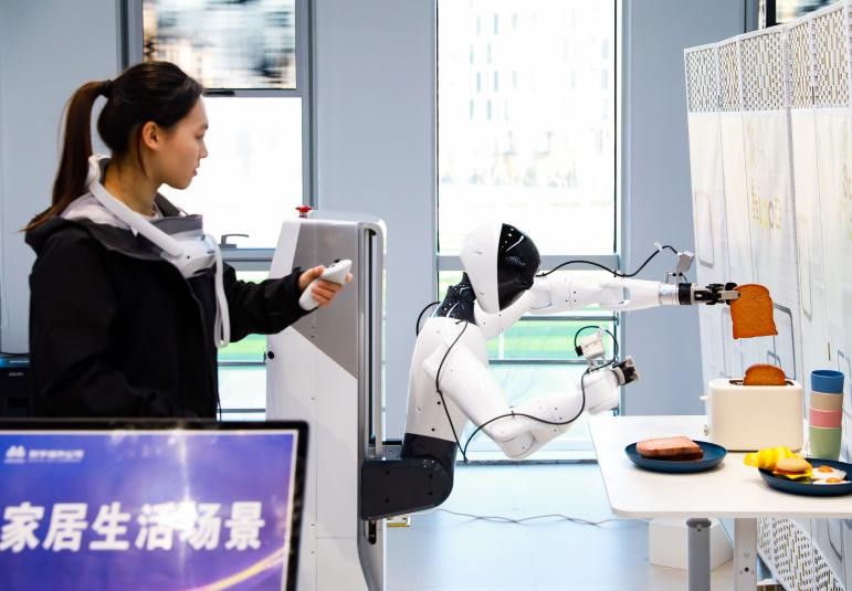 在中国雄安集团数字城市科技有限公司具身智能训练场，工作人员正在家居生活场景内训练机器人完成指定动作。记者 李兆民摄