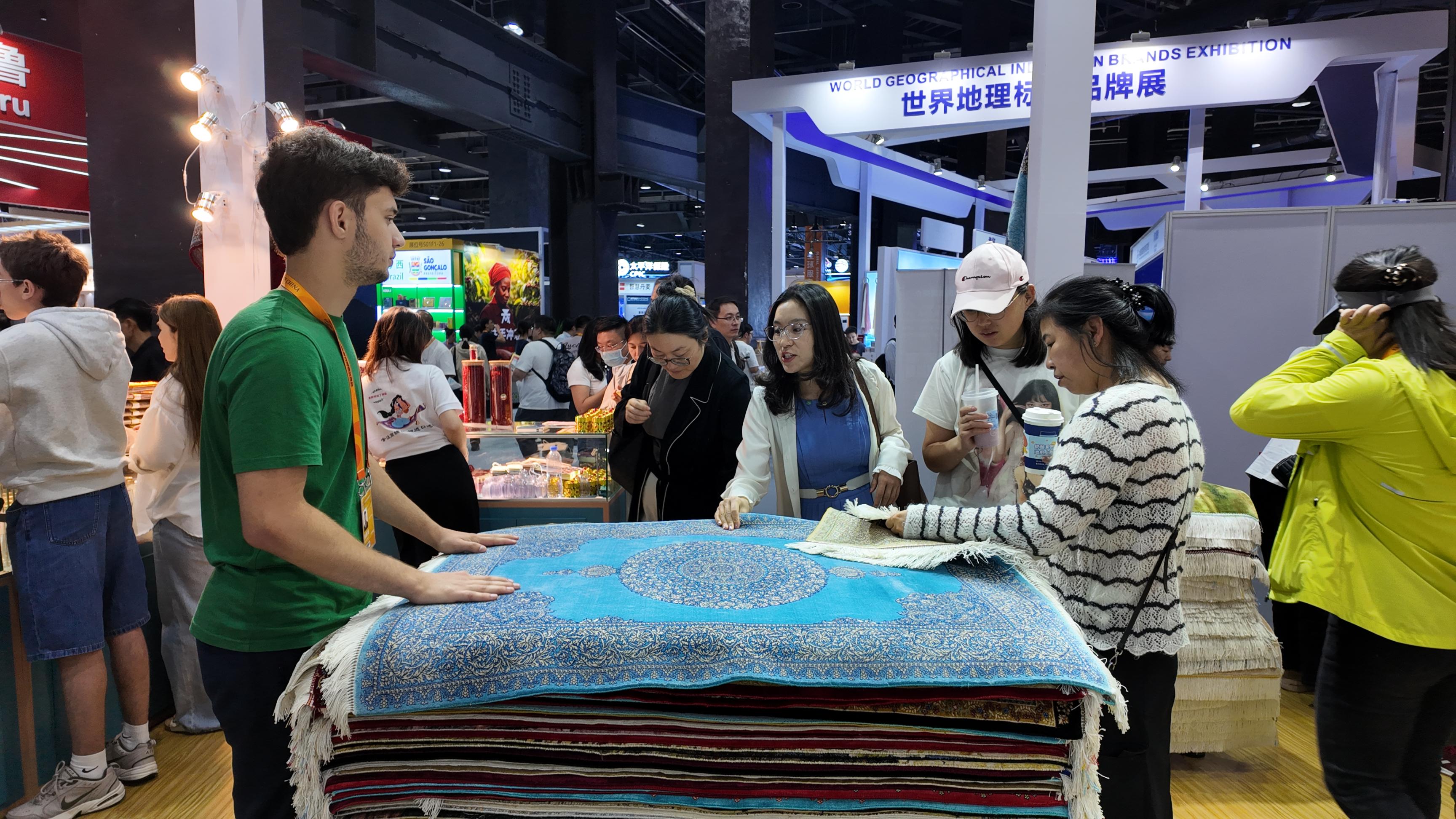 在伊朗展馆内，参展商向观众展示商品。人民网记者 欧阳易佳摄