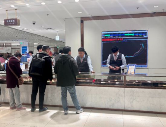 10月27日,在北京市菜市口百货投资金条柜台,顾客正在咨询商品。新华网记者 游苏杭 摄