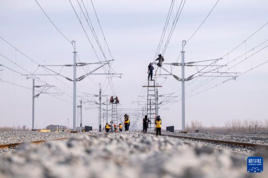 3月13日，工人在哈伊高铁绥化南站施工现场进行接触网作业。