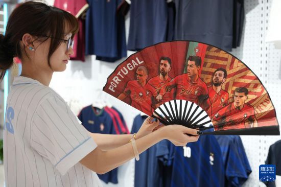 5月15日，义乌国际商贸城的商户展示获得授权设计生产的葡萄牙国家足球队折扇。