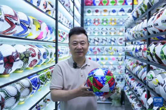 5月15日，在义乌国际商贸城专门销售球类的商户陈绍美展示今年自主设计生产的热销足球。