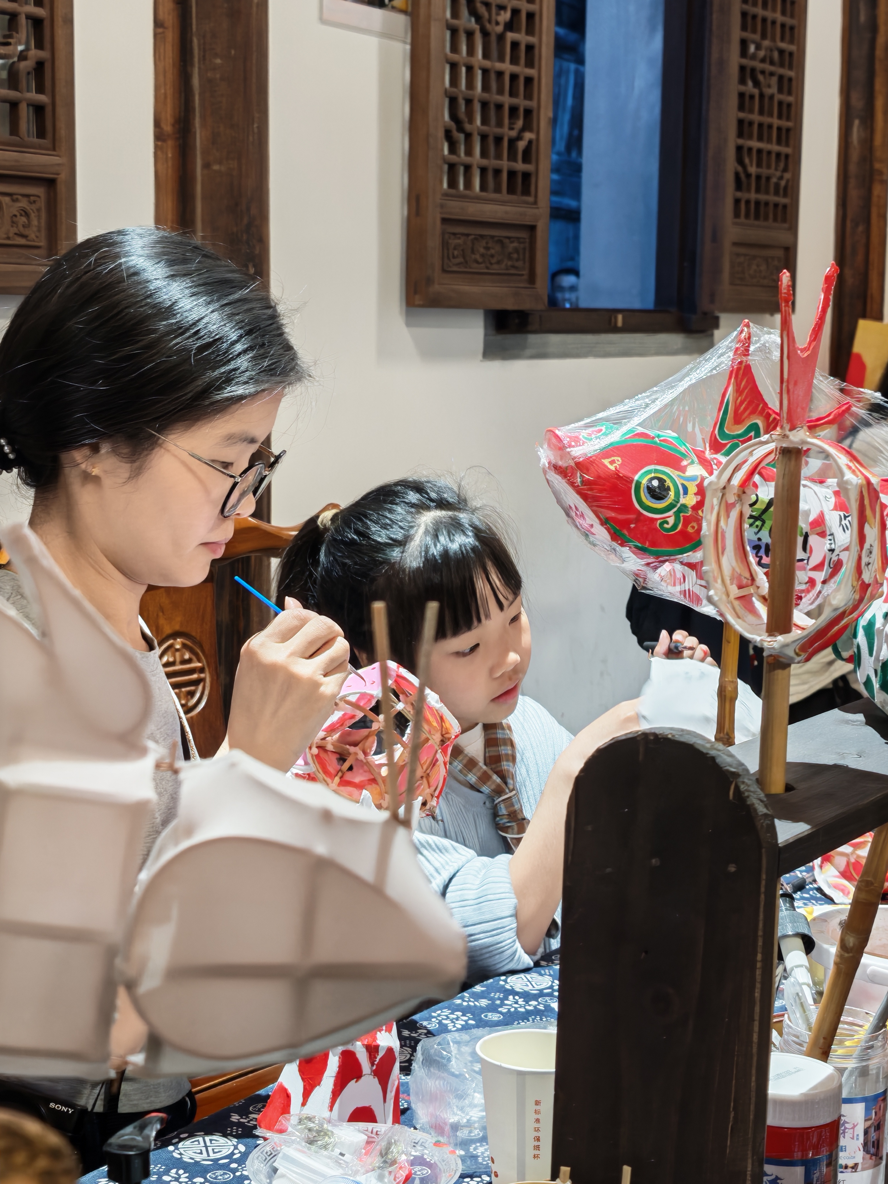 游客在体验鱼灯制作。（罗阳奇摄）