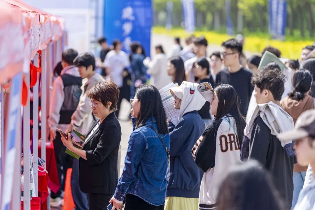 4月25日，山西省运城学院，学生在“就业公共服务进校园”专场招聘活动上与企业代表交流求职。兰立强摄